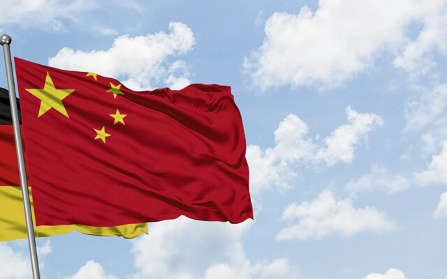 German and chinese flag with blue sky and white clouds in the background